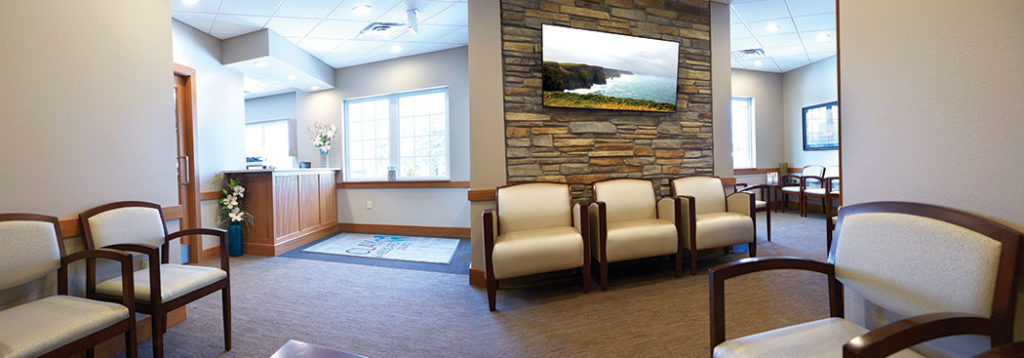 Clay & Associates DDS, PLC reception area is designed with sedate colors and tradition, rich furniture to give the room a class and timless look.