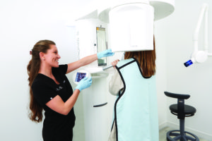 Dental hygienist using a 3D CBCT machine to capture images of the teeth